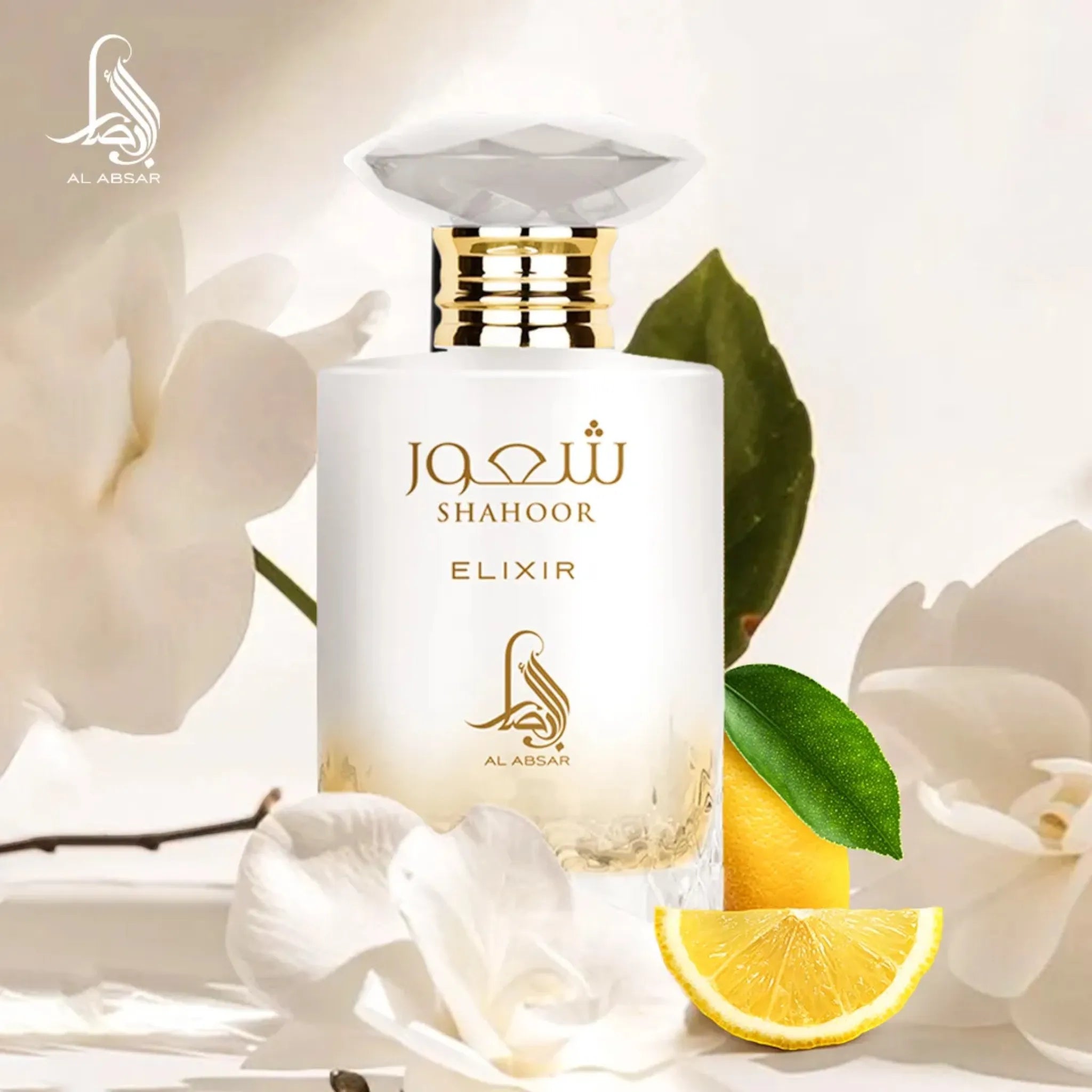 A bottle of Al Absar Shahoor elixir perfume with top notes listed as lemon, candy, and rum, middle notes as orange blossom and milk, and base notes as vanilla, benzoin, amber, and musk, presented alongside slices of lemon and a bar of soap.